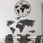 World map wall clock with world map cutout on a white wall above a conference table.