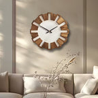 Wooden wall clock on a beige wall above a sofa with decorative branches.