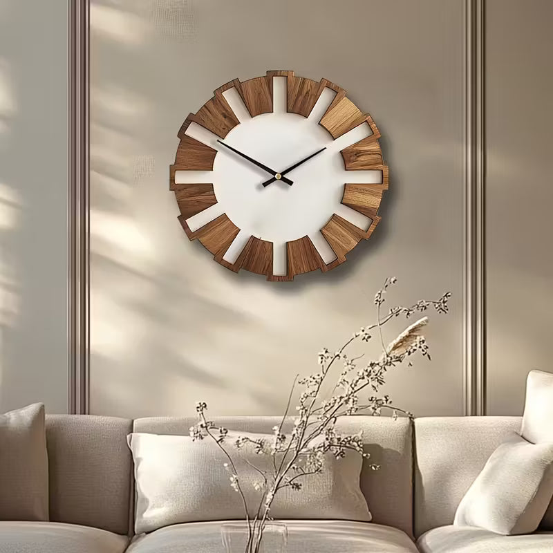 Wooden wall clock on a beige wall above a sofa with decorative branches.