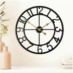 Decorative wall clock with black frame and gold hands on a light background