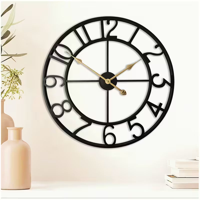 Decorative wall clock with black frame and gold hands on a light background