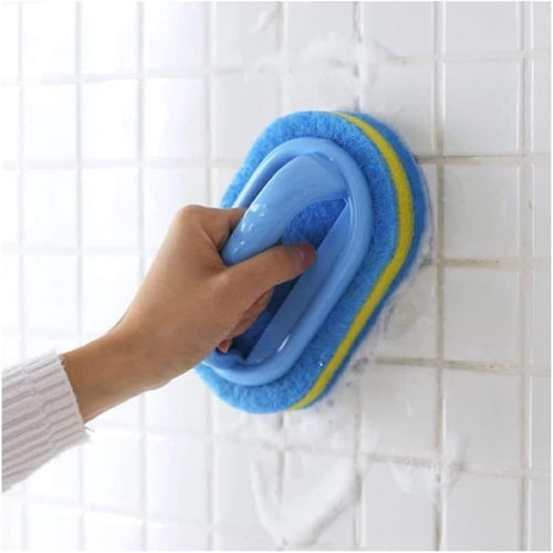 Hand using a blue scrubber with yellow handle on tiled wall