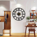 Large black wall clock on a white wall in a modern interior setting with wooden furniture.