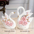 Decorative swan figurines with floral details and measurements on a marble surface.