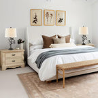 Neatly arranged bedroom with a bed, nightstands, and wall art.