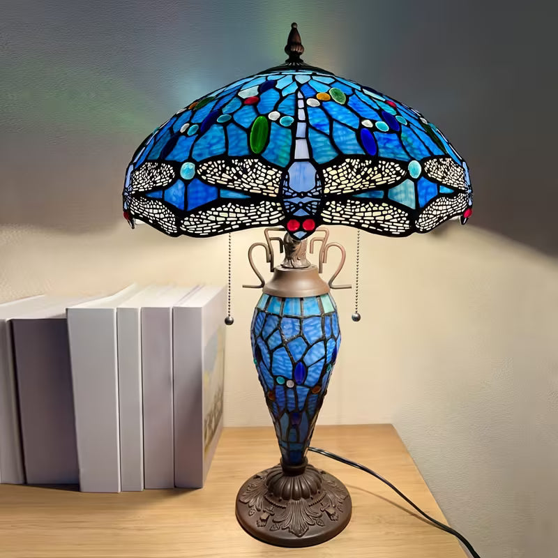 Stained glass lamp with dragonfly design on a wooden surface