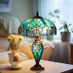 Decorative table lamp with stained glass shade on a surface, with a blurred background