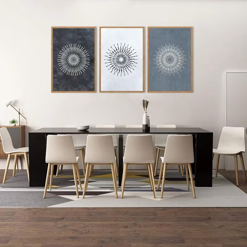 Dining room with a black table and beige chairs, featuring three abstract wall art pieces.