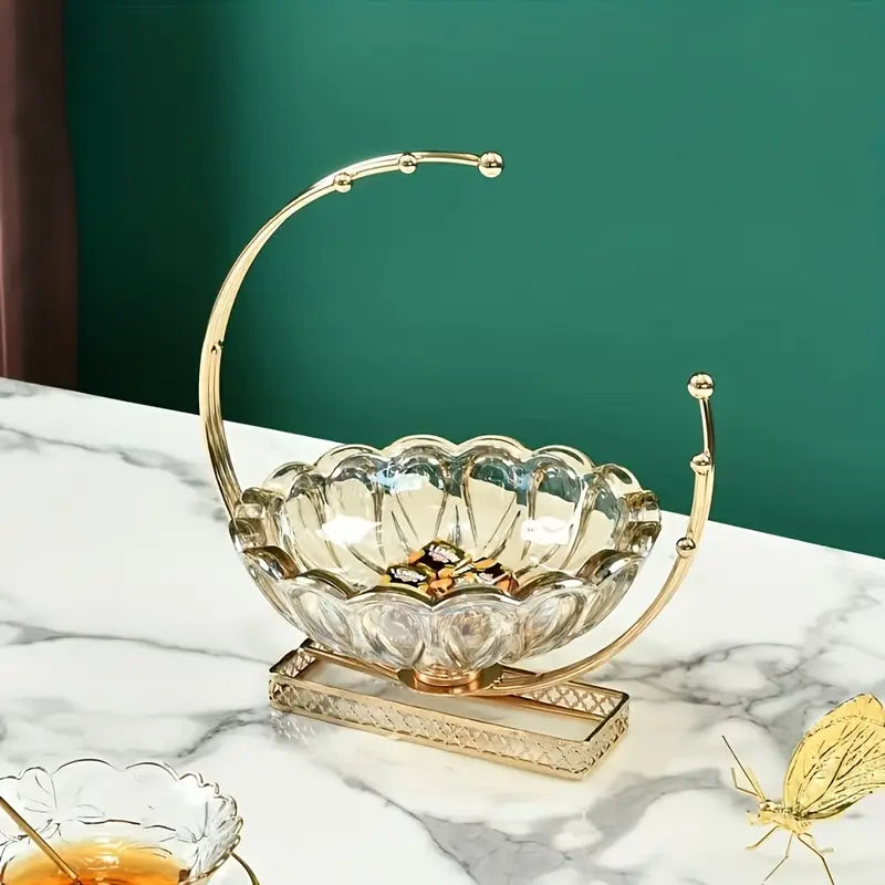 Decorative glass bowl with gold rim on a marble surface against a green wall