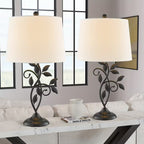 Two decorative table lamps with leaf designs on a marble surface in a living room setting.