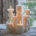Set of white textured candles on a table with a blurred background